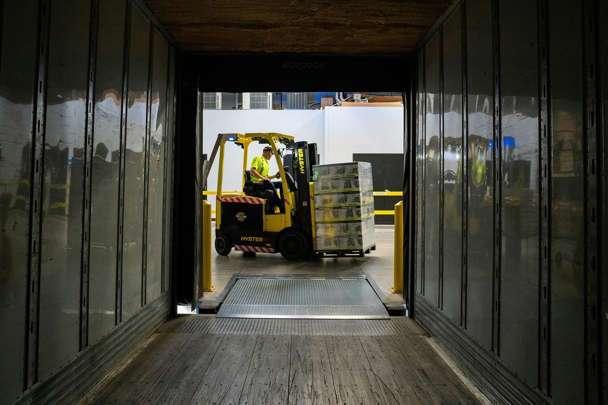 Warehouse worker operating a forklift at a loading dock